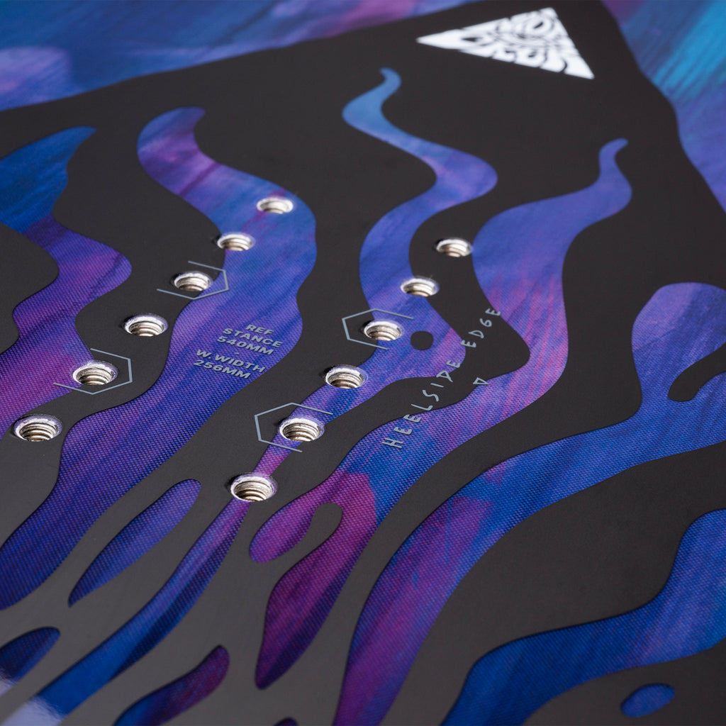 GammaAPX- Close-up of a snowboard deck with purple and blue flame design and brand logo.