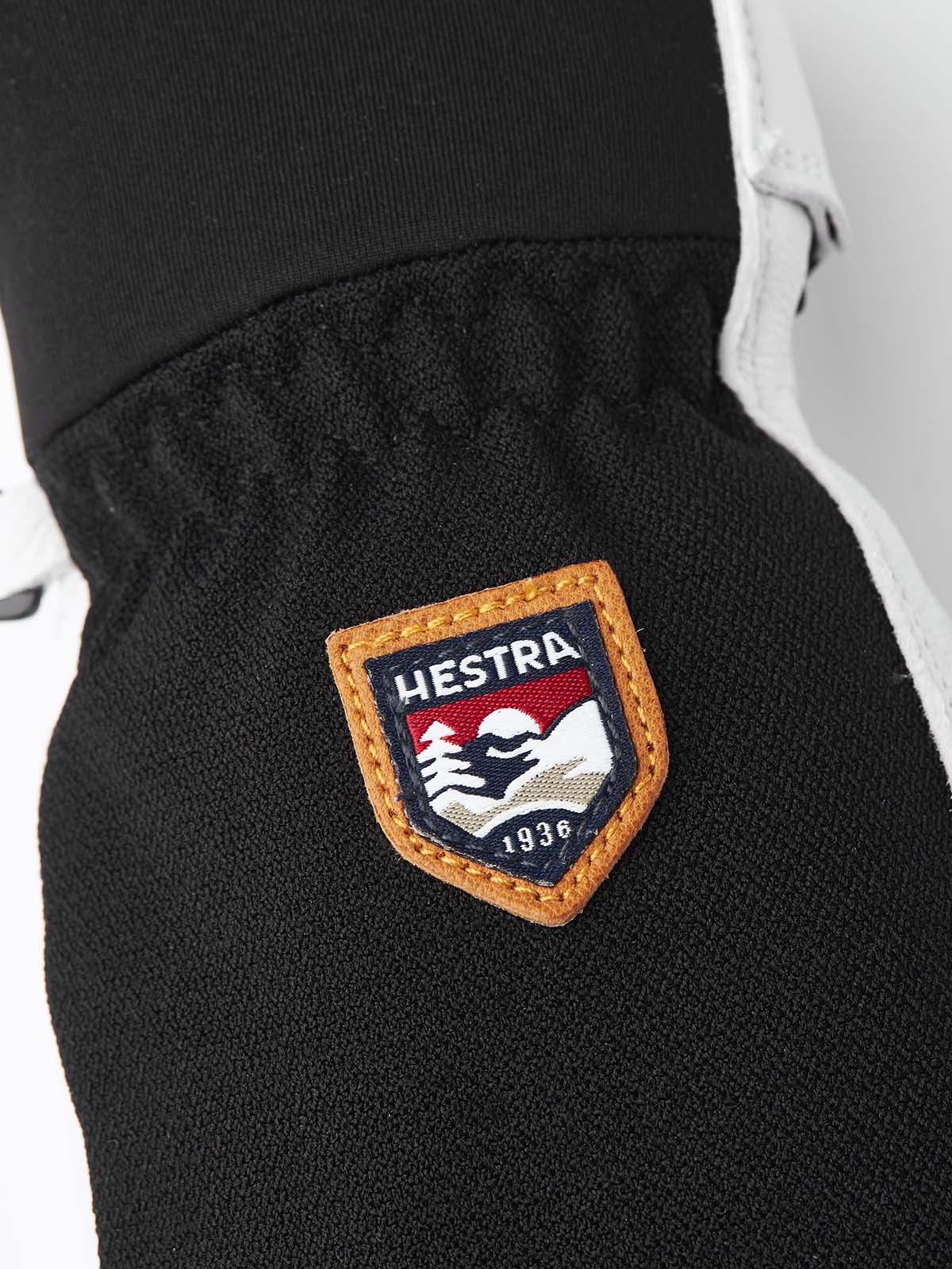 ArmyLeatherPatrolMitt-Pair of white and black mittens with a visible brand logo on a white background