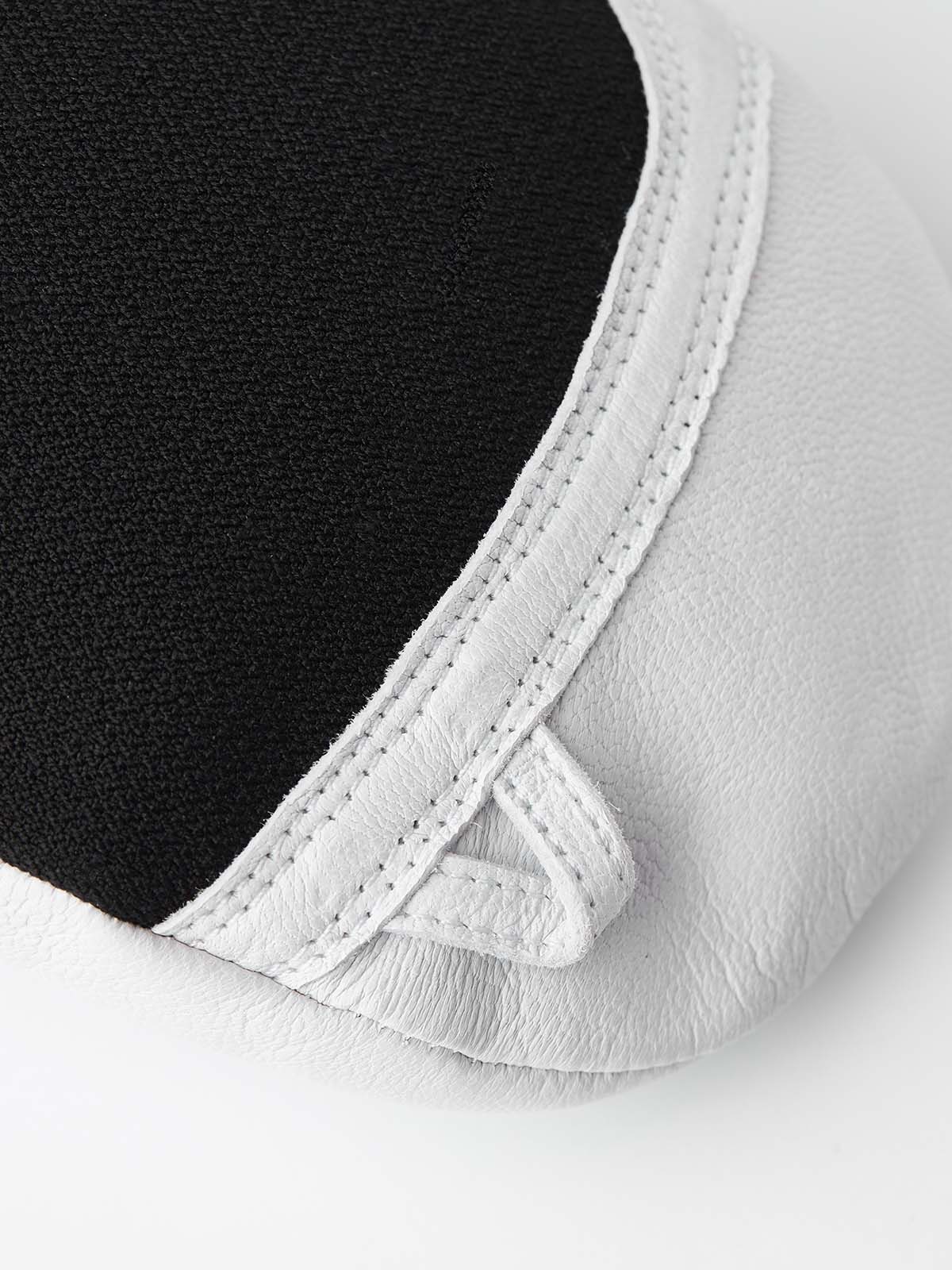 ArmyLeatherPatrolMitt-Pair of white and black mittens with a visible brand logo on a white background