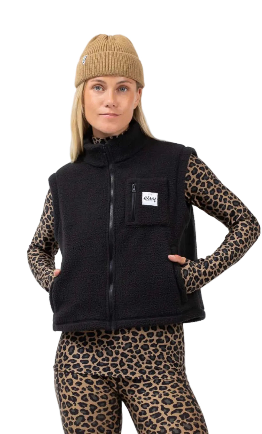 BoxySherpaVest-Person wearing a black vest with a brand logo, leopard print sleeves, pants, and beanie on a white background