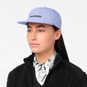 LogoFlatCap-Woman wearing a light blue Salomon cap on a white background