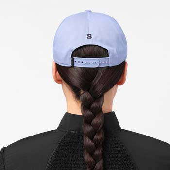 LogoFlatCap-Person wearing a light blue cap with a brand logo, facing away from the camera.