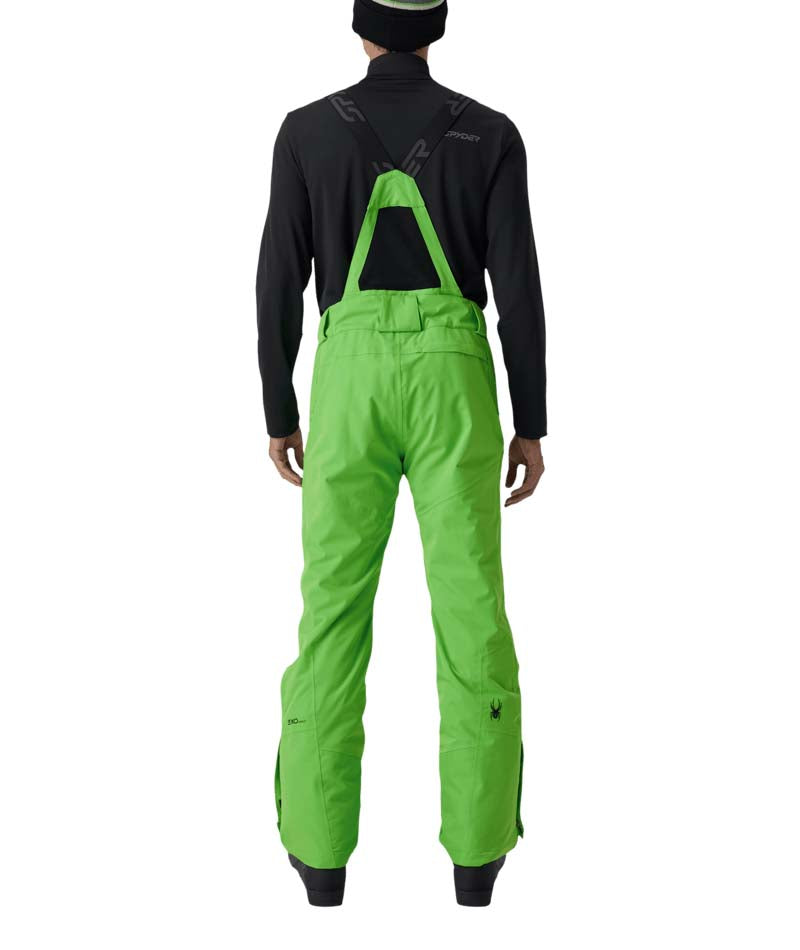 MDarePant- Man wearing green snow pants with black overalls on a white background