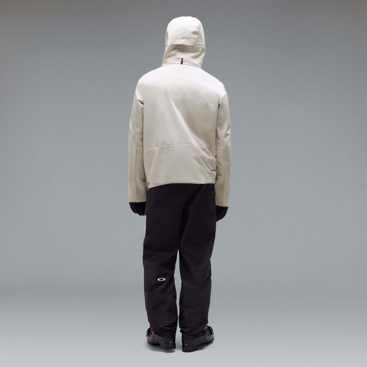 MTimberlineShellAnorak-An off-white hooded anorak jacket with a large black Oakley logo on the chest, displayed against a neutral gray gradient background.