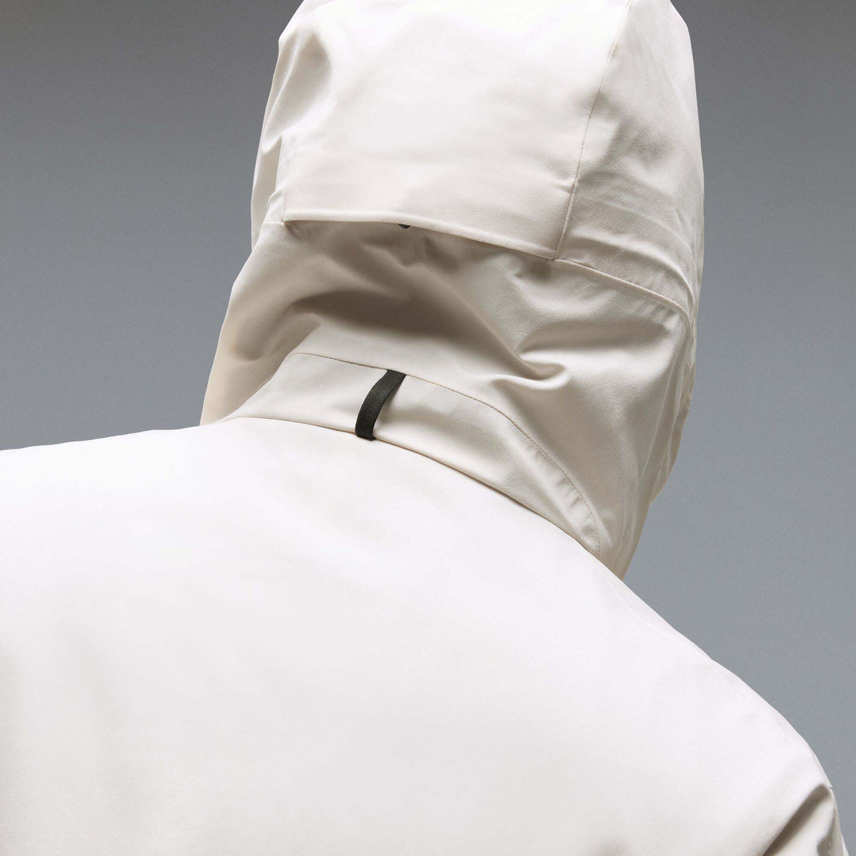 MTimberlineShellAnorak-An off-white hooded anorak jacket with a large black Oakley logo on the chest, displayed against a neutral gray gradient background.