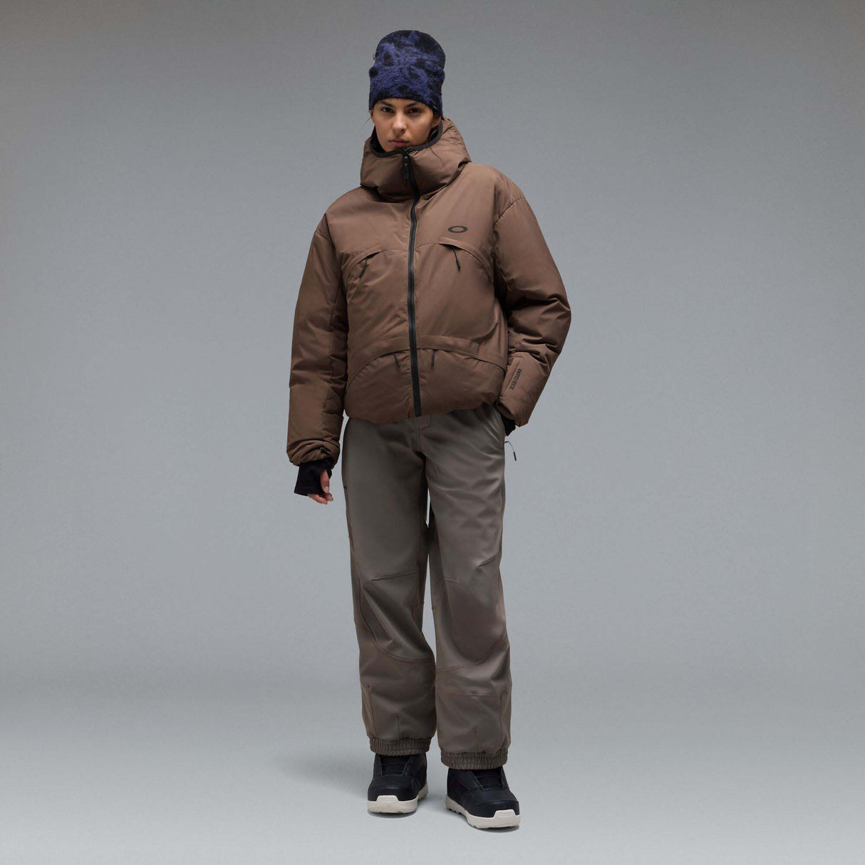 MWintertideSoftshellPant-A pair of gray snow pants with a black belt and a small black Oakley logo on the left thigh, displayed against a neutral gray gradient background.
