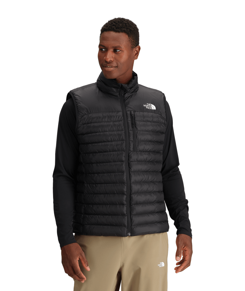 M Terra Peak Vest- Man wearing a black puffer vest with a visible brand logo on a white background