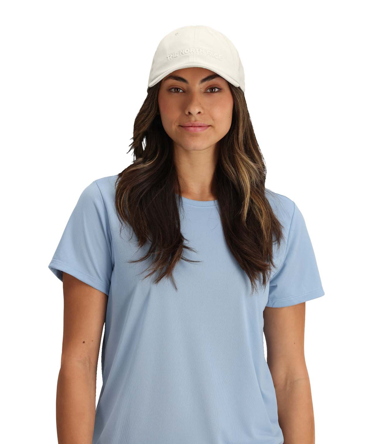 RoomyNormHat- Woman wearing a light blue t-shirt and white cap on a white background