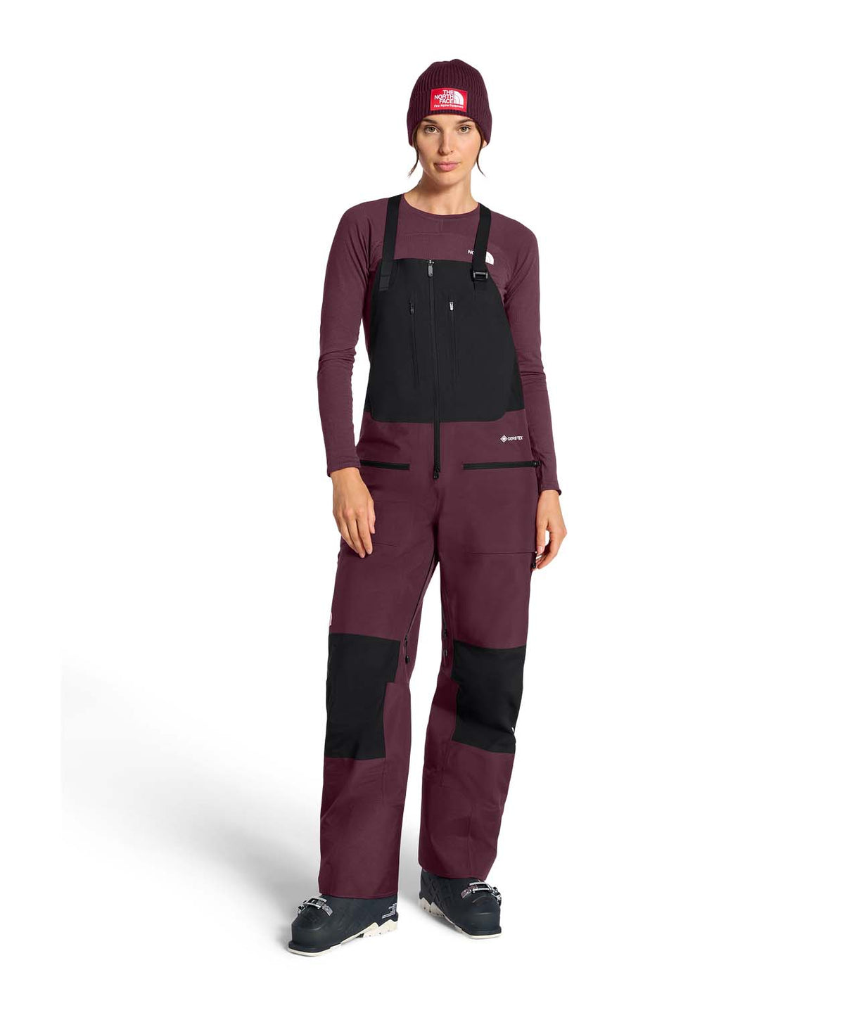 WSummitVerbierGTXBib-Person wearing a maroon snowsuit with black accents on a white background