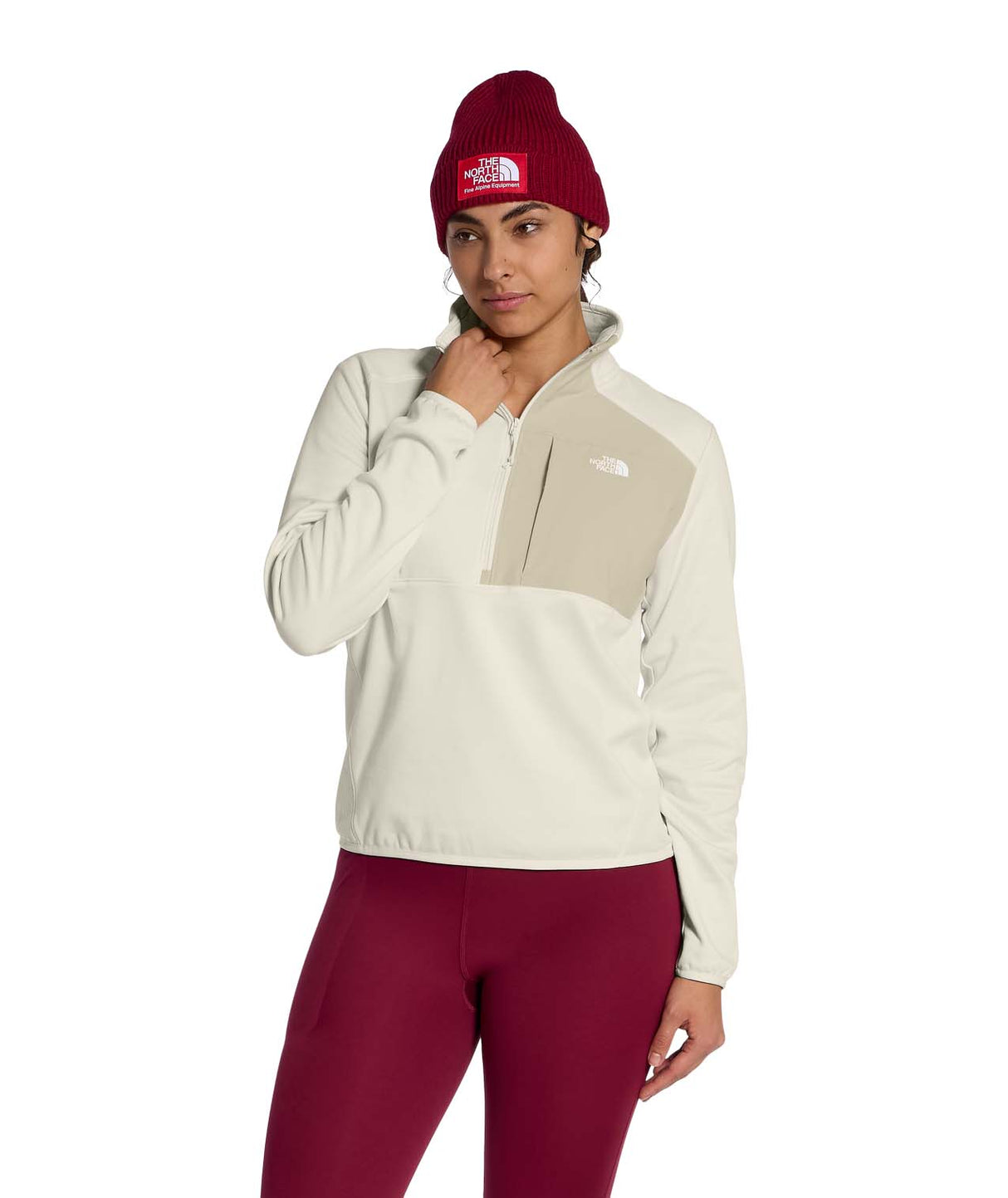 WTNFPerformanceFleece1_4Zip- Person wearing a beige and brown color-blocked jacket with a red beanie on a white background