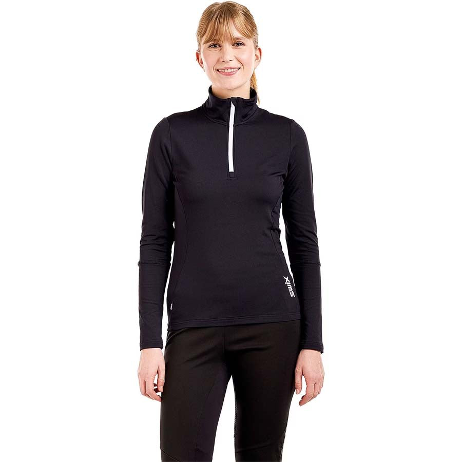 WTista1_2ZipMidlayer- A woman modeling a black long-sleeve half-zip athletic top with a white zipper pull, paired with black leggings, against a plain white background.