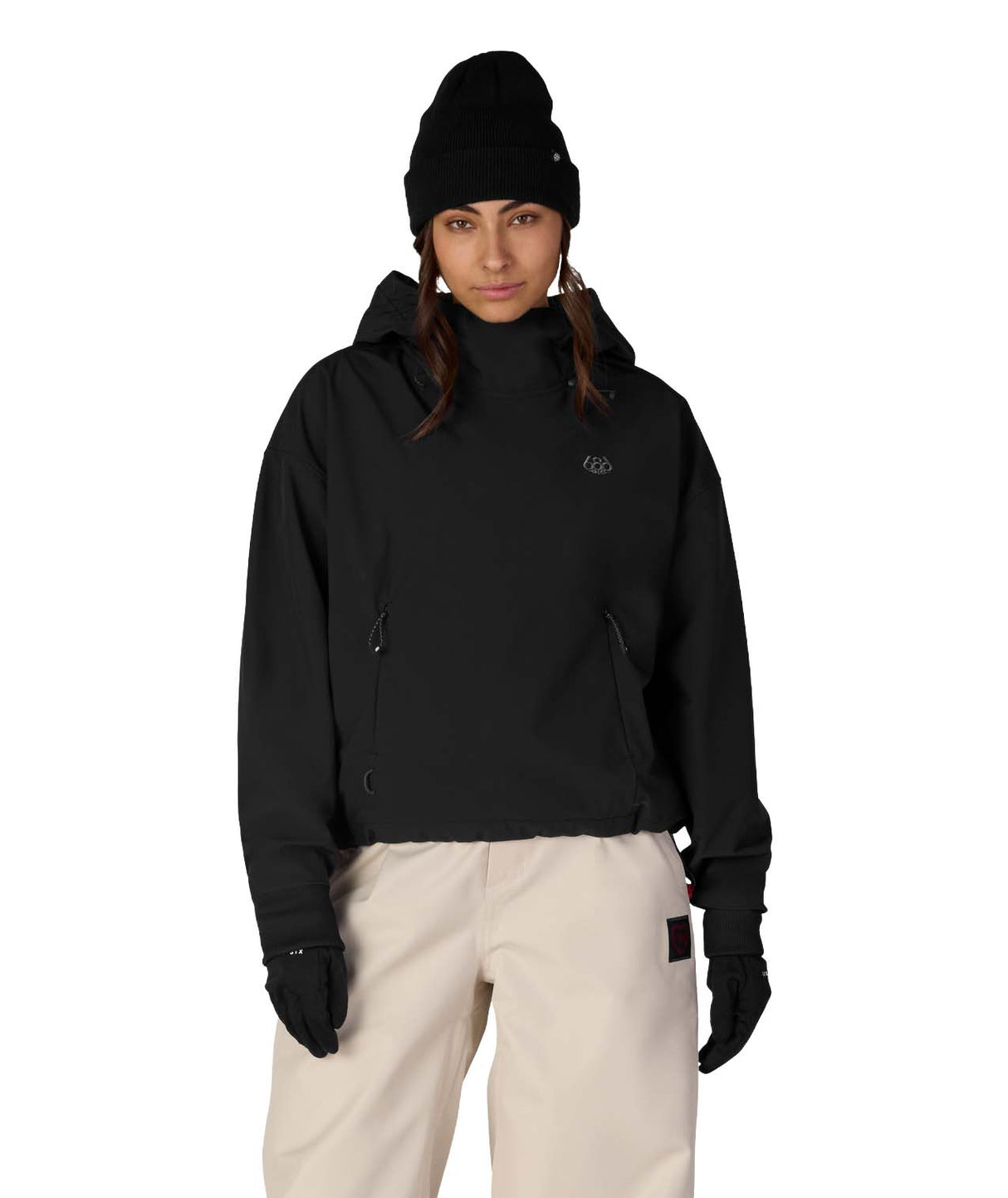 WWaterproofTeamCropHoody-Person wearing a black jacket, black beanie, and beige pants on a white background