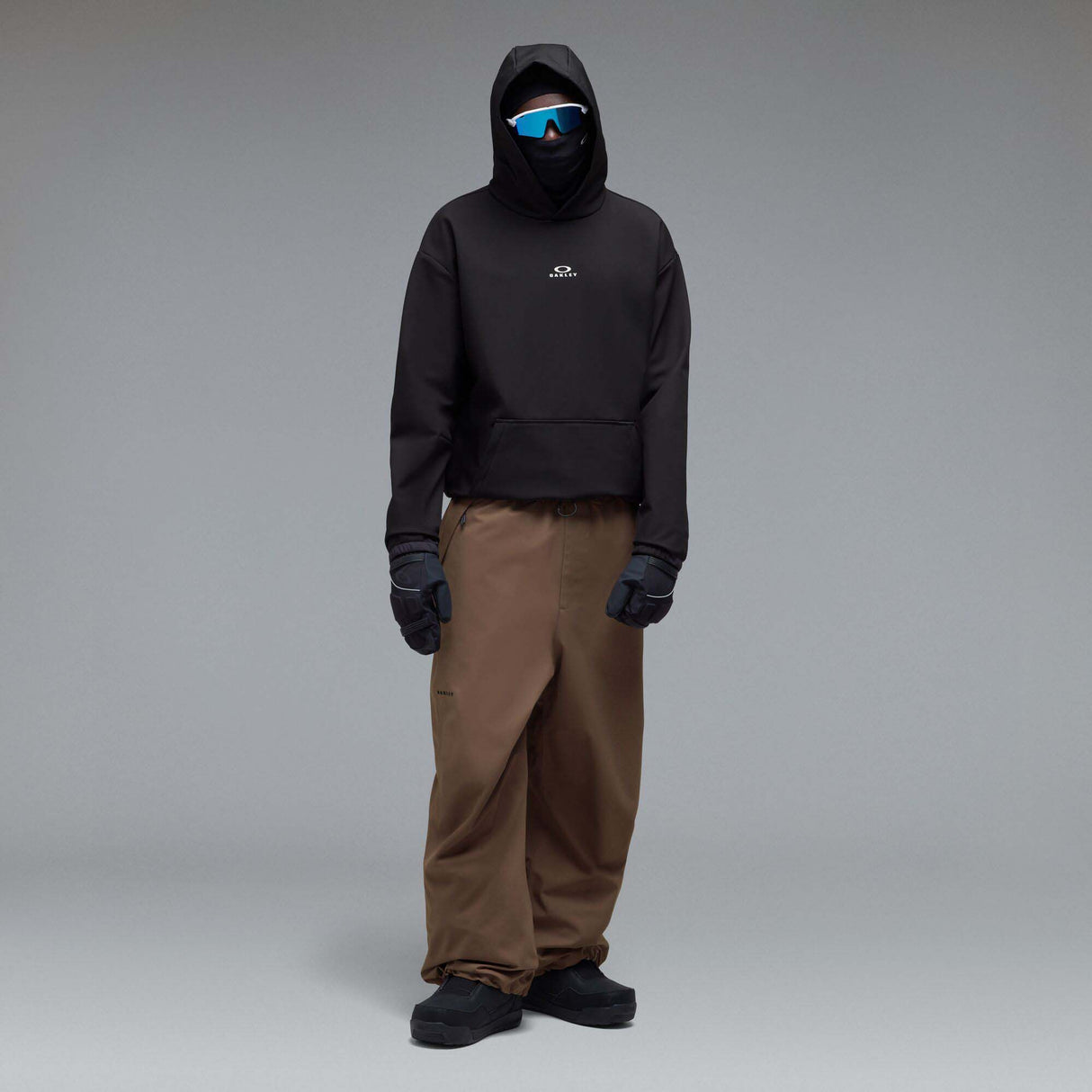 WintertideScratchedHoodie-A black pullover hoodie with a small white Oakley logo on the left chest, displayed against a neutral gray gradient background.