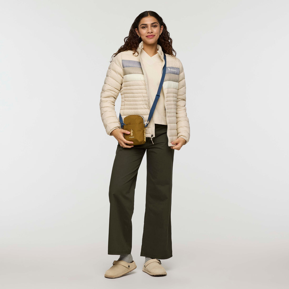 w-fuego-down-jacket- A beige quilted puffer jacket with a gray chest stripe and a visible Cotopaxi logo on the left chest, displayed against a clean white background.