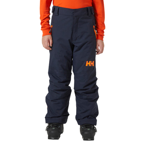 Legendary Pant-Navy snow pants with orange logo worn by a person on a white background