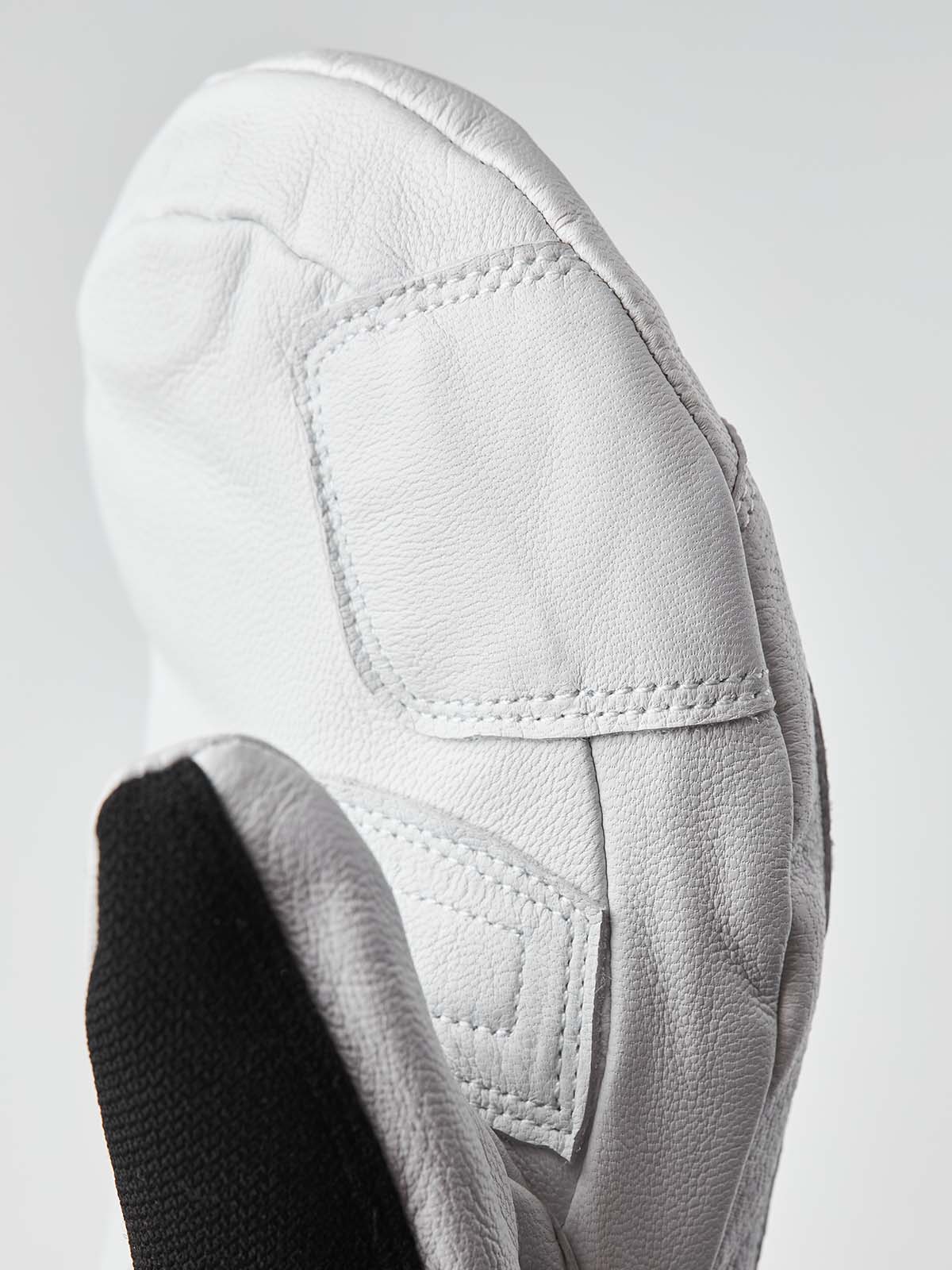 ArmyLeatherPatrolMitt-Pair of white and black mittens with a visible brand logo on a white background
