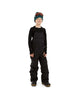BaileyPant-A child model wearing black snow bib overalls, a black long-sleeve shirt, a dark green beanie with ski goggles, and black snow boots, standing against a solid white background.