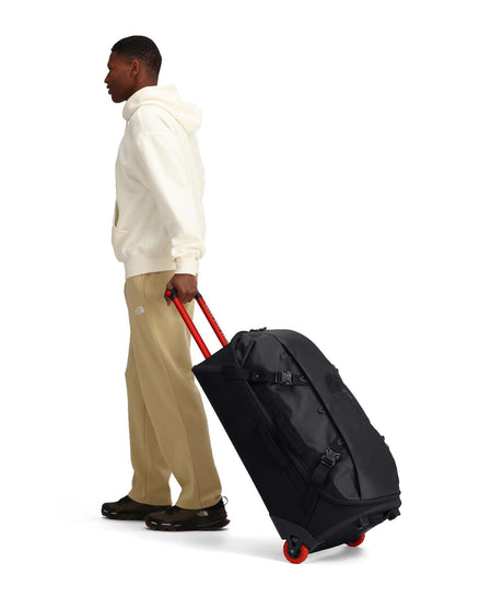 BaseCampRollingThunder_28-Black rolling duffel bag with red wheels on a white background