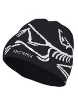 BirdHeadToque-A black knit beanie hat featuring a white knit Arc'teryx bird logo and the brand name 'ARC'TERYX' on the side, with a black fleece lining visible at the opening.