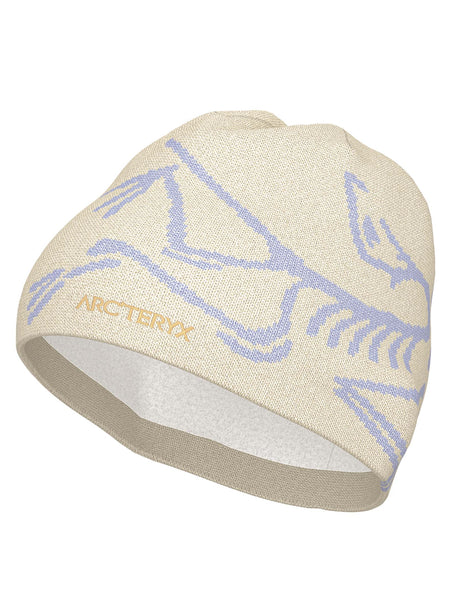 BirdHeadToque-A light beige knit beanie hat featuring a light purple knit Arc'teryx bird logo and the brand name 'ARC'TERYX' on the side, with a white fleece lining visible at the opening.