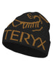 BirdWordToque-A black knit beanie featuring the Arc'teryx wordmark and bird logo in tan/golden brown, shown on a plain white background.