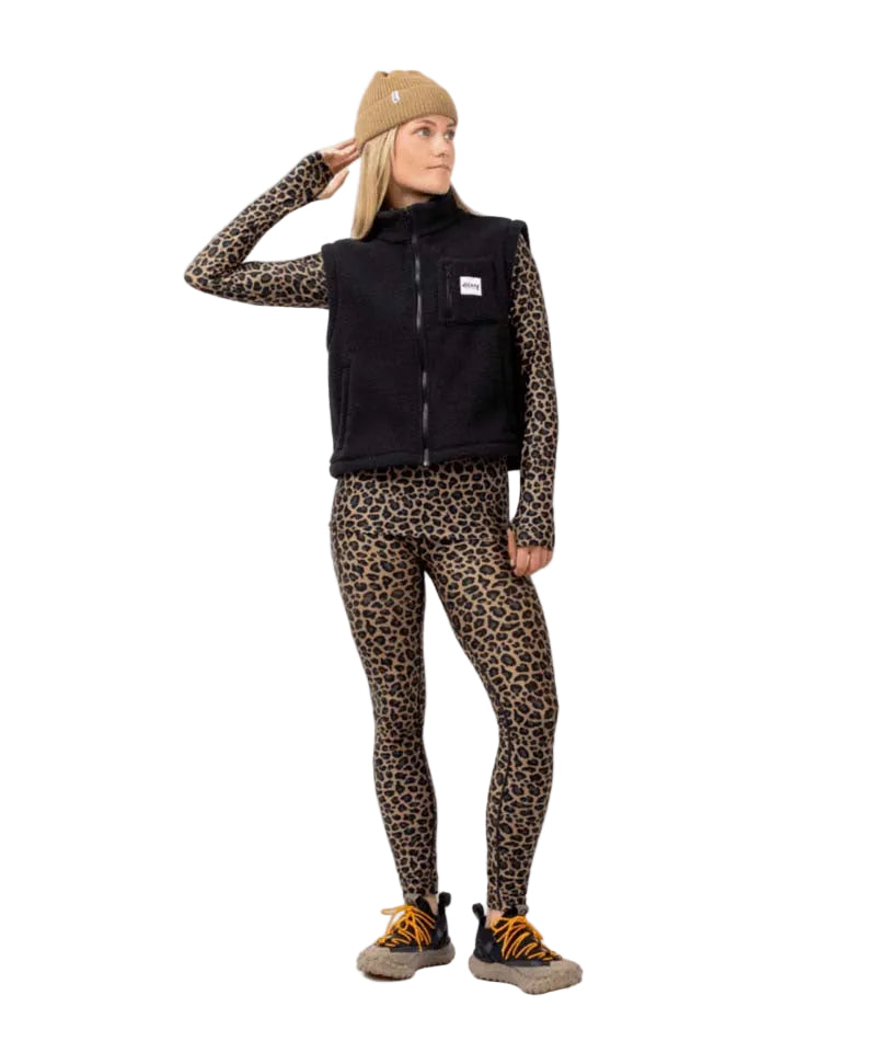 BoxySherpaVest-Person wearing a black vest with a brand logo, leopard print sleeves, pants, and beanie on a white background