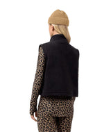 BoxySherpaVest-Person wearing a black vest with a brand logo, leopard print sleeves, pants, and beanie on a white background