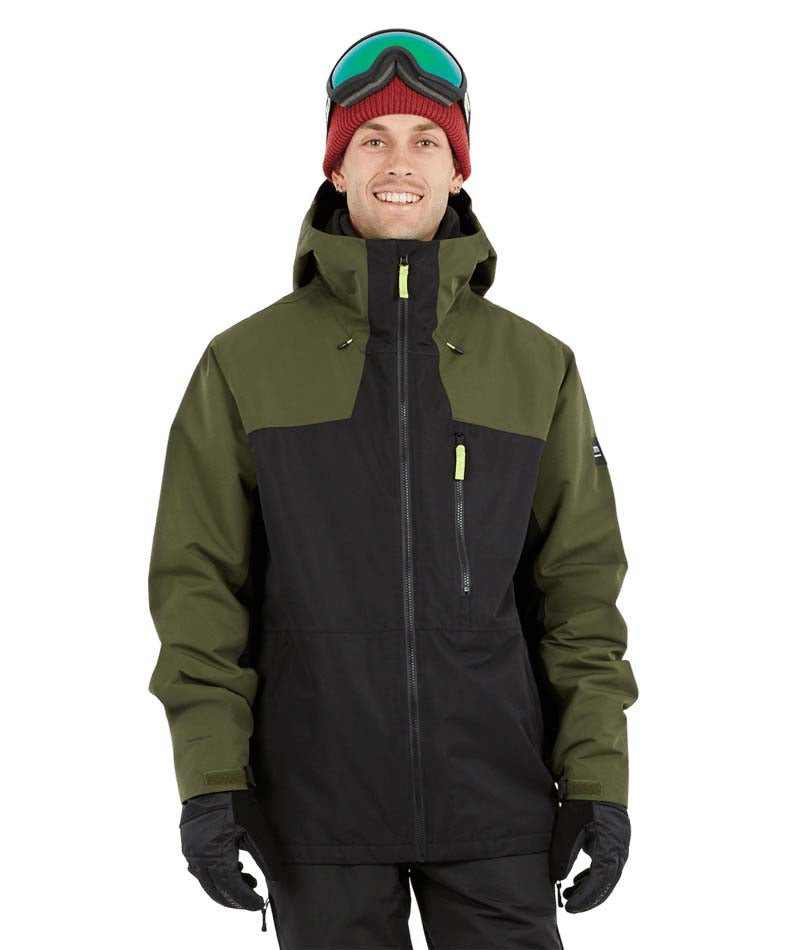 DescentJacket-A man wearing a colorblock snowboard jacket in olive green and black, paired with a red knit beanie, green-tinted ski goggles, and black gloves, against a plain white background.