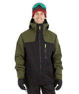 DescentJacket-A man wearing a colorblock snowboard jacket in olive green and black, paired with a red knit beanie, green-tinted ski goggles, and black gloves, against a plain white background.