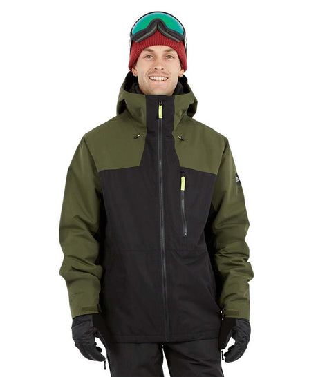 DescentJacket-A man wearing a colorblock snowboard jacket in olive green and black, paired with a red knit beanie, green-tinted ski goggles, and black gloves, against a plain white background.