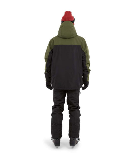 DescentJacket-A man wearing a colorblock snowboard jacket in olive green and black, paired with a red knit beanie, green-tinted ski goggles, and black gloves, against a plain white background.