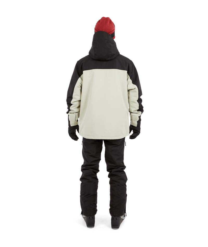DescentJacket-A man wearing a black and off-white ski jacket with black gloves, a red knit beanie, and ski goggles, photographed against a solid white background.