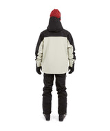 DescentJacket-A man wearing a black and off-white ski jacket with black gloves, a red knit beanie, and ski goggles, photographed against a solid white background.