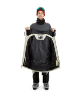 DescentJacket-A man wearing a black and off-white ski jacket with black gloves, a red knit beanie, and ski goggles, photographed against a solid white background.