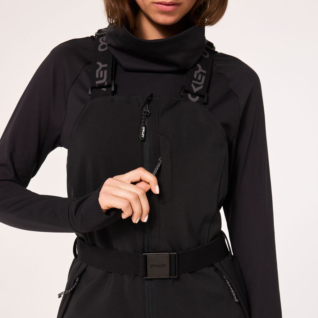 WTNPHarperSoftshellBib-Black ski jumpsuit with a belt on a light gray background