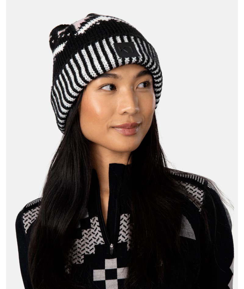 FaithBeanie-Woman wearing a black and white patterned beanie and jacket against a white background