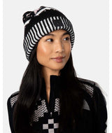 FaithBeanie-Woman wearing a black and white patterned beanie and jacket against a white background