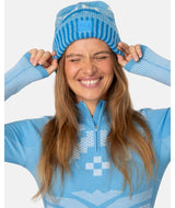 FaithBeanie-Woman wearing a blue ski suit with matching hat on a white background