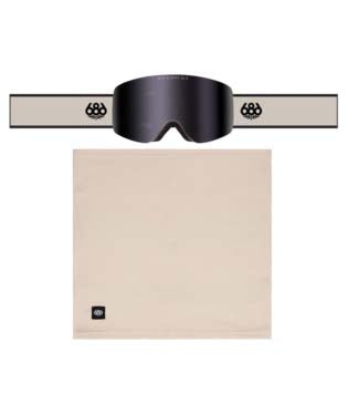 FoundationGogglePack-A pair of black ski goggles with a wide beige strap, shown above a matching beige neck gaiter. The goggles feature a dark tinted lens and a strap with a circular logo, while the neck gaiter has a small square logo in the lower left corner.