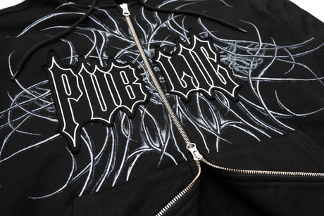 GeneralZipUp-Close-up of a black zip-up hoodie featuring a large white gothic-style 'PUBLIC' graphic and white sketch-style line art across the chest, with a silver zipper.