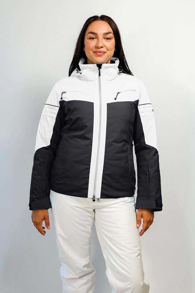HelenaWomensInsulatedJacket-A woman modeling a colorblock ski jacket in white and black, paired with white ski pants, against a light gray studio background.