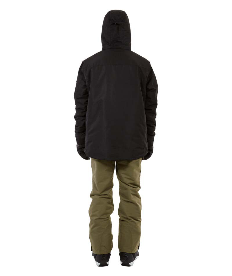 KnoxJacket-A man wearing a black snowboard jacket, black beanie with goggles, and gray gloves, standing against a solid white background.
