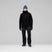 LofotenGore-TexJkt-Person wearing a black jacket, pants, and blue beanie on a gray background