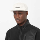 LogoFlatCap-Man wearing a white Salomon cap on a white background