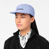 LogoFlatCap-Woman wearing a light blue Salomon cap on a white background