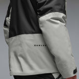MCanopyProInsulatedJacket-A colorblock hooded jacket with a black upper section and sleeves, a light gray midsection, and a black lower section, featuring a full-zip front and a small white Oakley logo on the chest.
