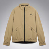 MChannelJacket-A beige lightweight zip-up jacket with a black front zipper, black side zip pockets, and a small black Oakley logo on the left chest, displayed against a neutral gray gradient background.
