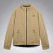 MChannelJacket-A beige lightweight zip-up jacket with a black front zipper, black side zip pockets, and a small black Oakley logo on the left chest, displayed against a neutral gray gradient background.