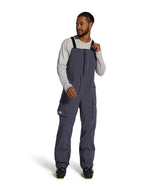 MFreedomBib- Man wearing grey bib overalls with The North Face logo on a white background