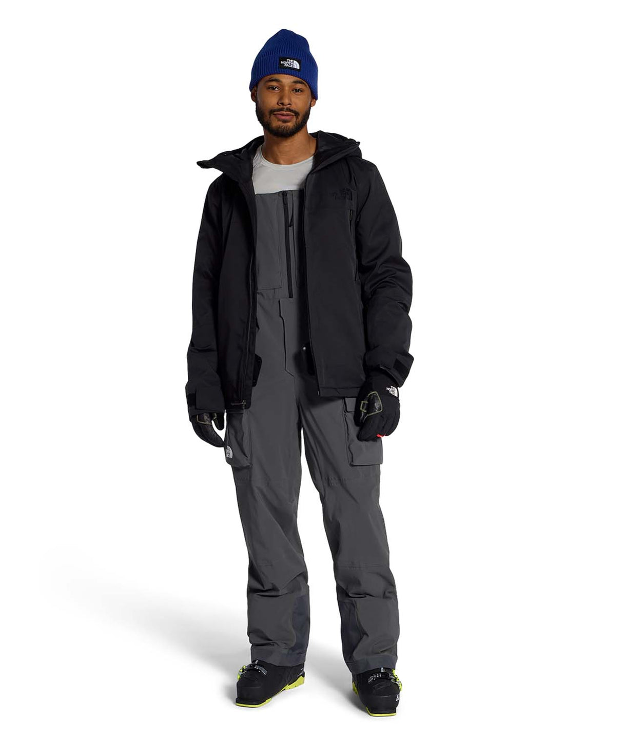 MFreedomBib- Man wearing grey bib overalls with The North Face logo on a white background